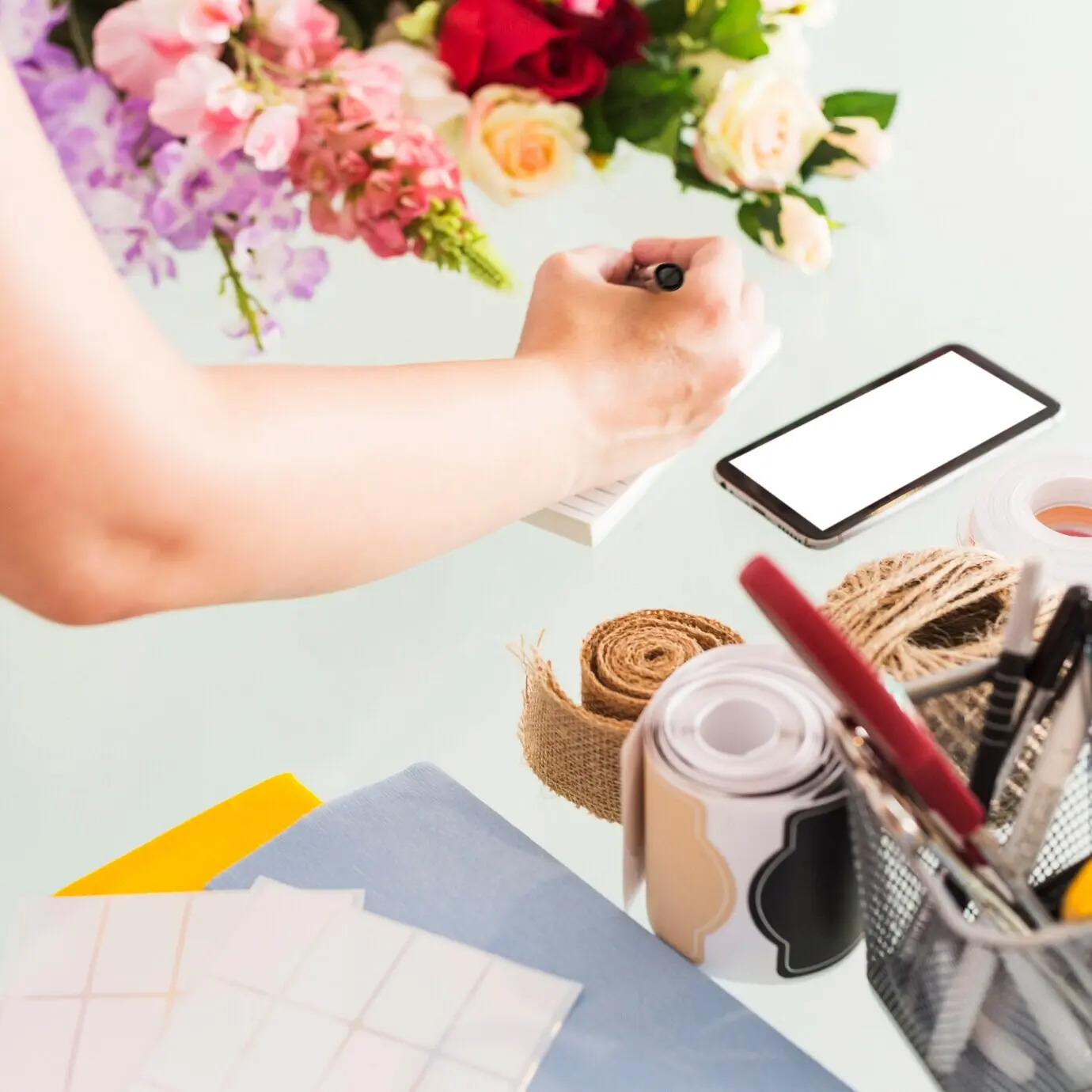 Nahaufnahme der Hand einer Frau, die auf einem Notizblock Notizen schreibt.